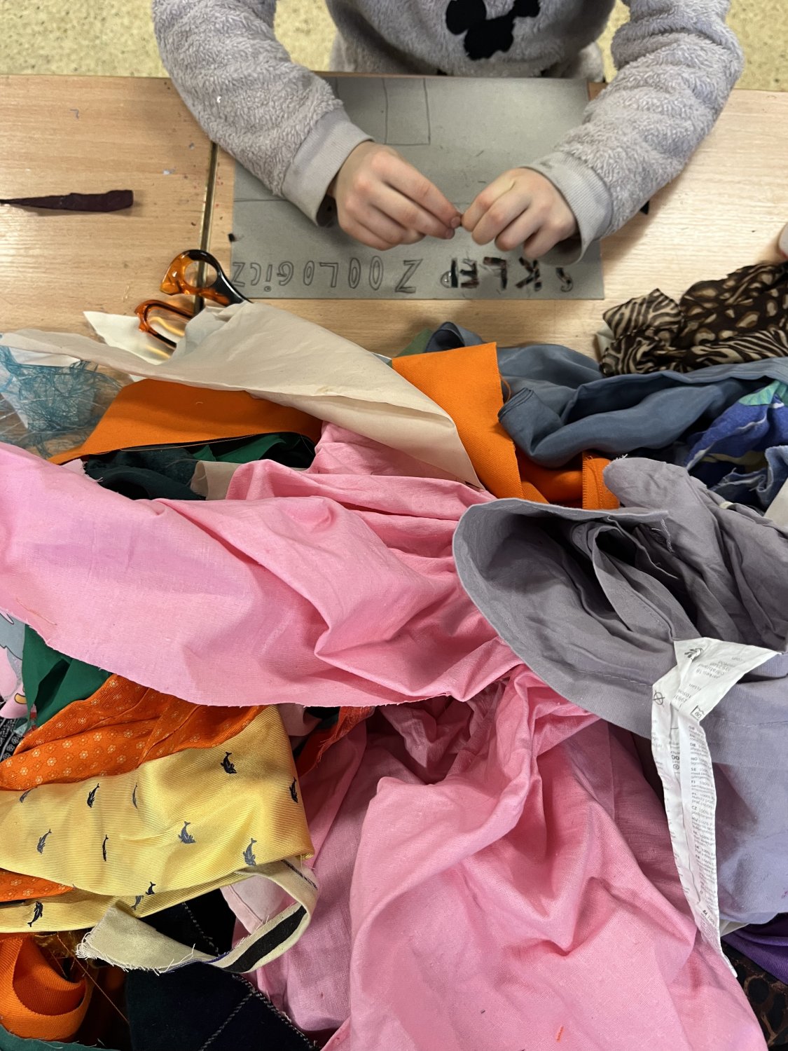 kolorowe tkaniny z których dzieci wycinają fragmenty do stworzenia swoich prac o ulubionych miejscach we Wrocławiu.