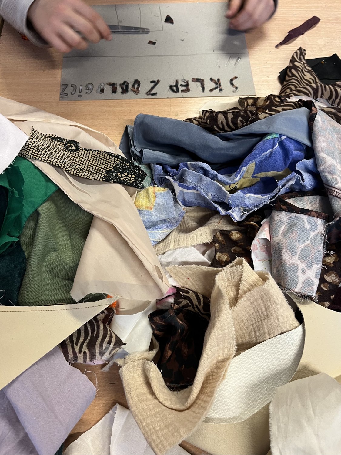 dziecko podczas kreatywnej pracy twórczej wykonuje z kawałków tkanin kolaż przedstawiający ulubione miejsce we Wrocławiu