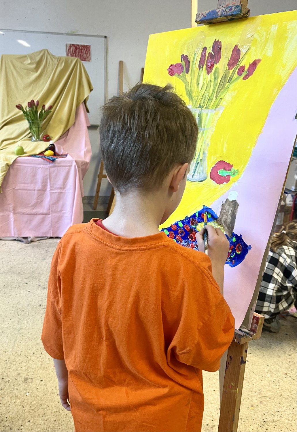 Chłopiec przy sztaludze podczas pracy nad studium martwej natury,