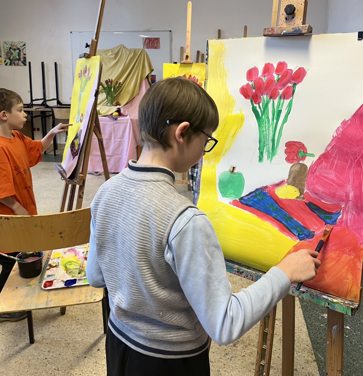 Widok pracowni na pierwszym planie chłopiec przy sztaludze