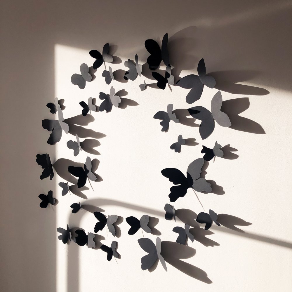 Papierowe motyle, które rozmieszczone na ścianie tworzą efekt 3D.